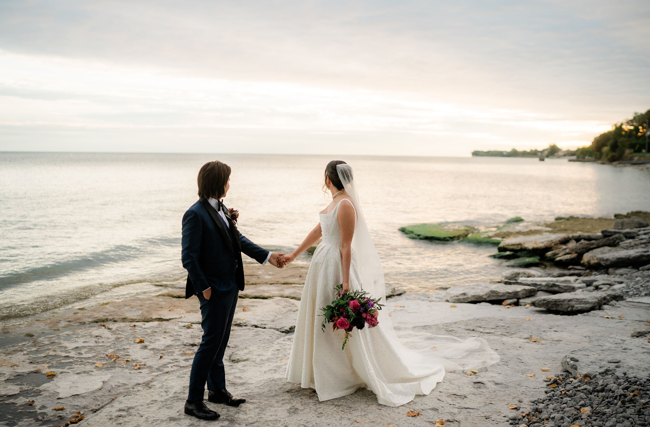 Bride and groom walking by Lake Ontario at Drake Devonshire wedding