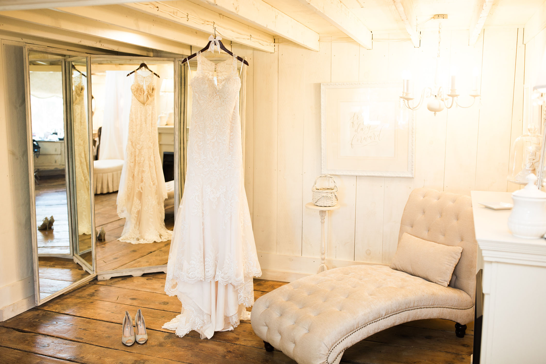Image of dress and shoes hanging in the bridal prep suite.