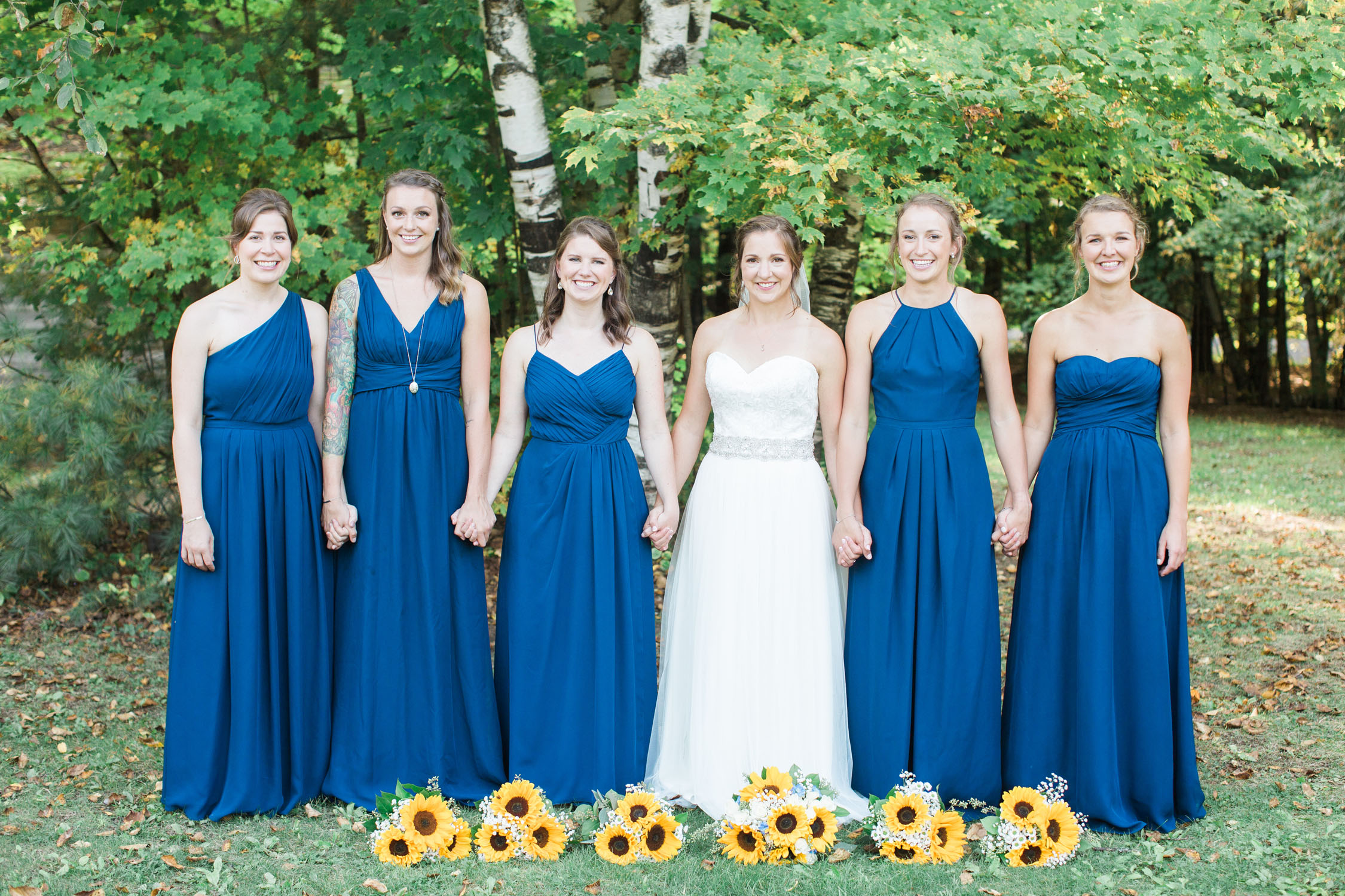 Bride and bridemaids dressed in blue with sunflowers.