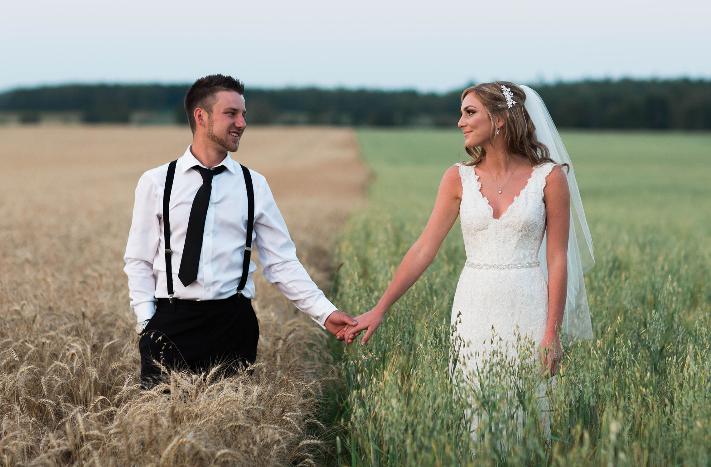 Bride and groom sharing a pic in the middle of the corn fields.