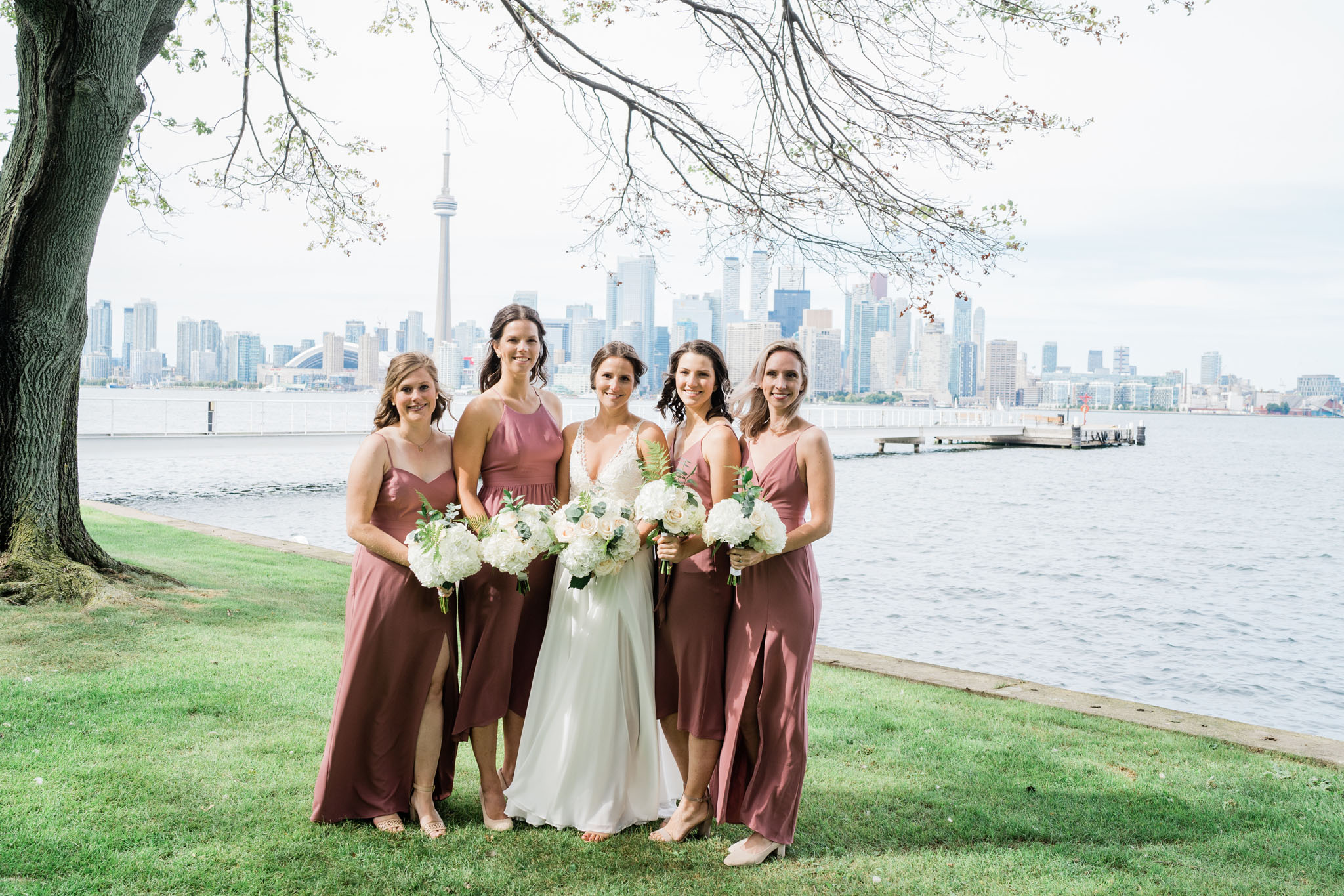 Bride with bridesmaids on the estate grounds with the Toronto skyline as a backdrop. Perfect RCYC wedding