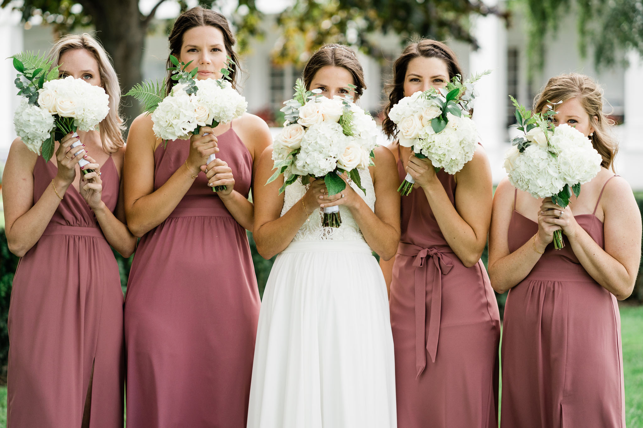 Bridesmaids all peaking out from behind their flowers.