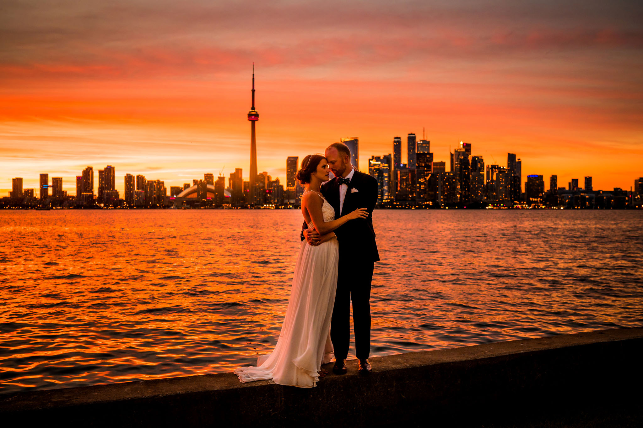 Sunset at the Royal Canadian Yacht Club. Gorgeous couple with red orange background. This one is definitely going in a frame!