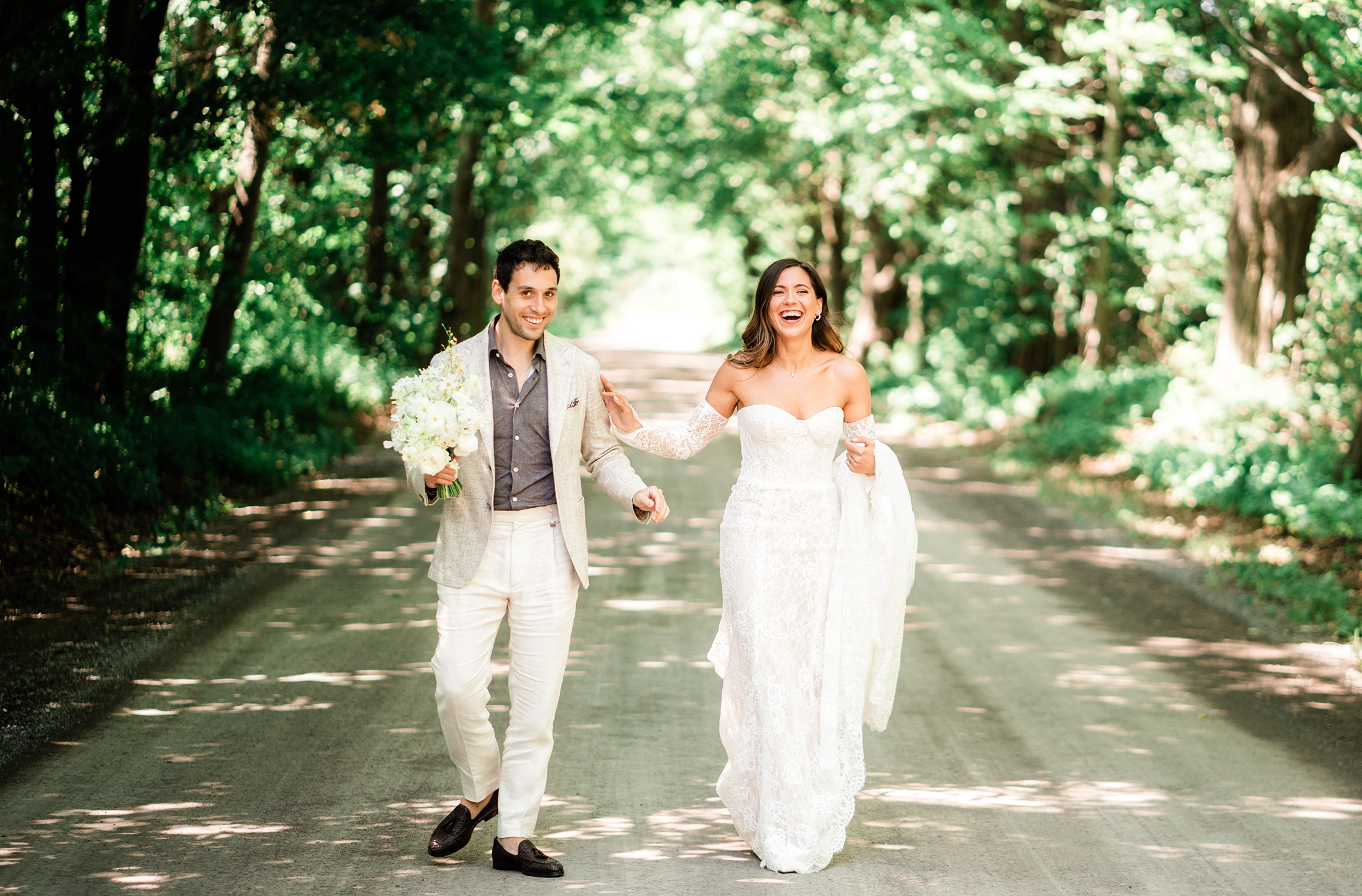 Compass Rose wedding photographer — bride and groom on the tree-lined lane in Prince Edward County.