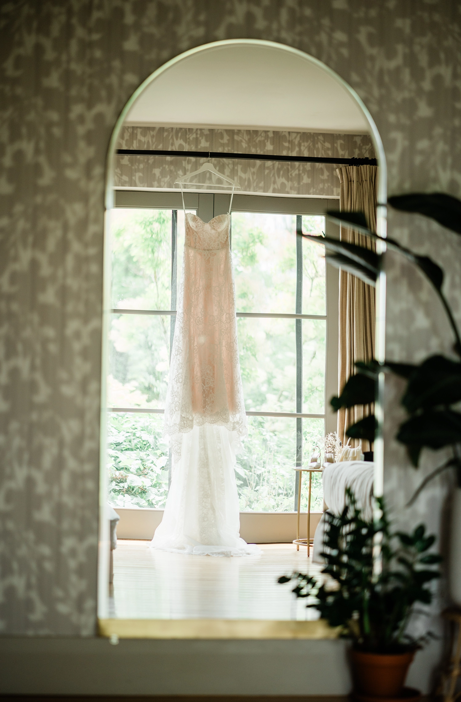 Wedding dress reflected in a mirror in the getting-ready suite at Compass Rose Suites.