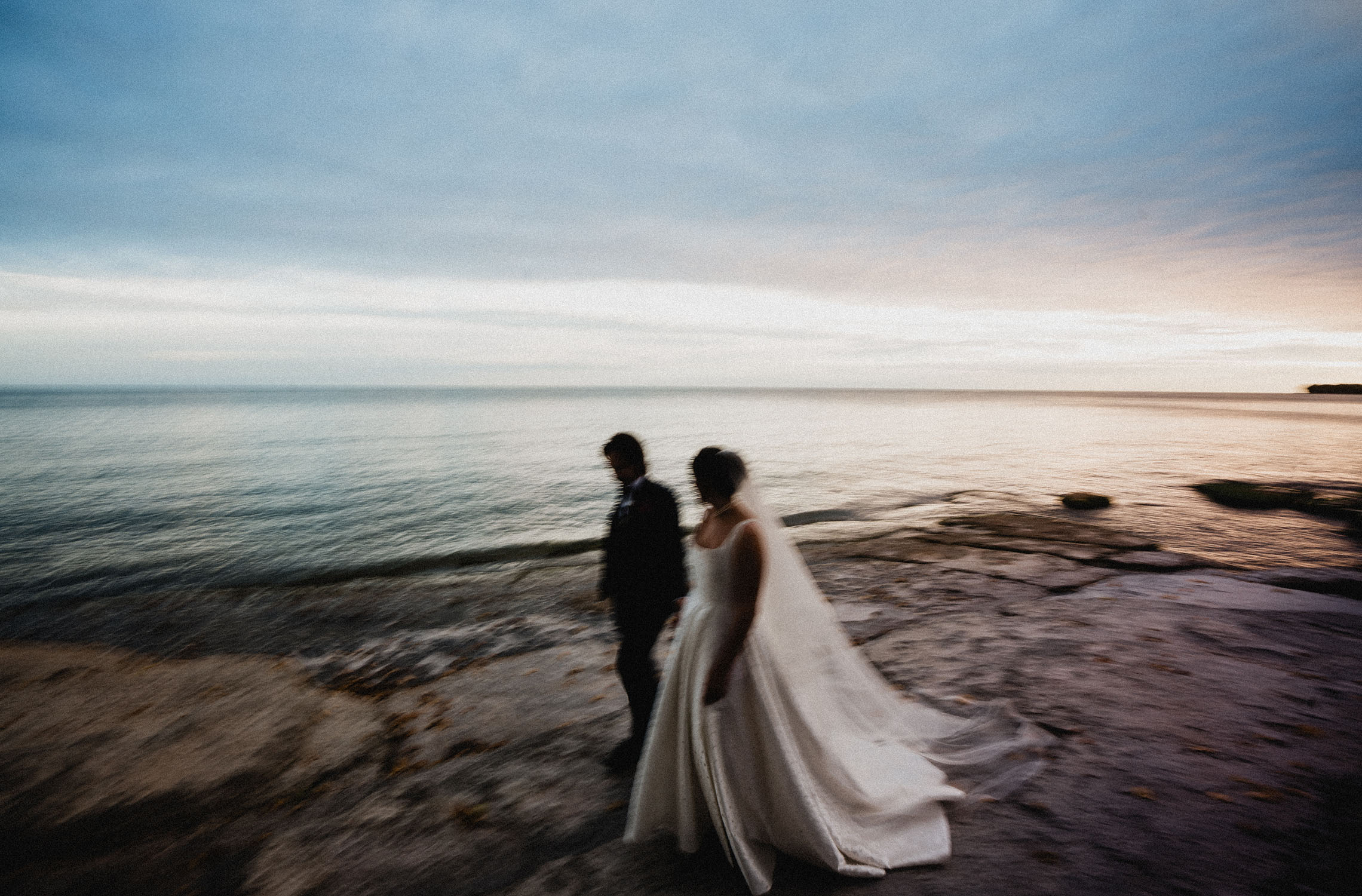 Bride and groom walking by Lake Ontario at Drake Devonshire wedding