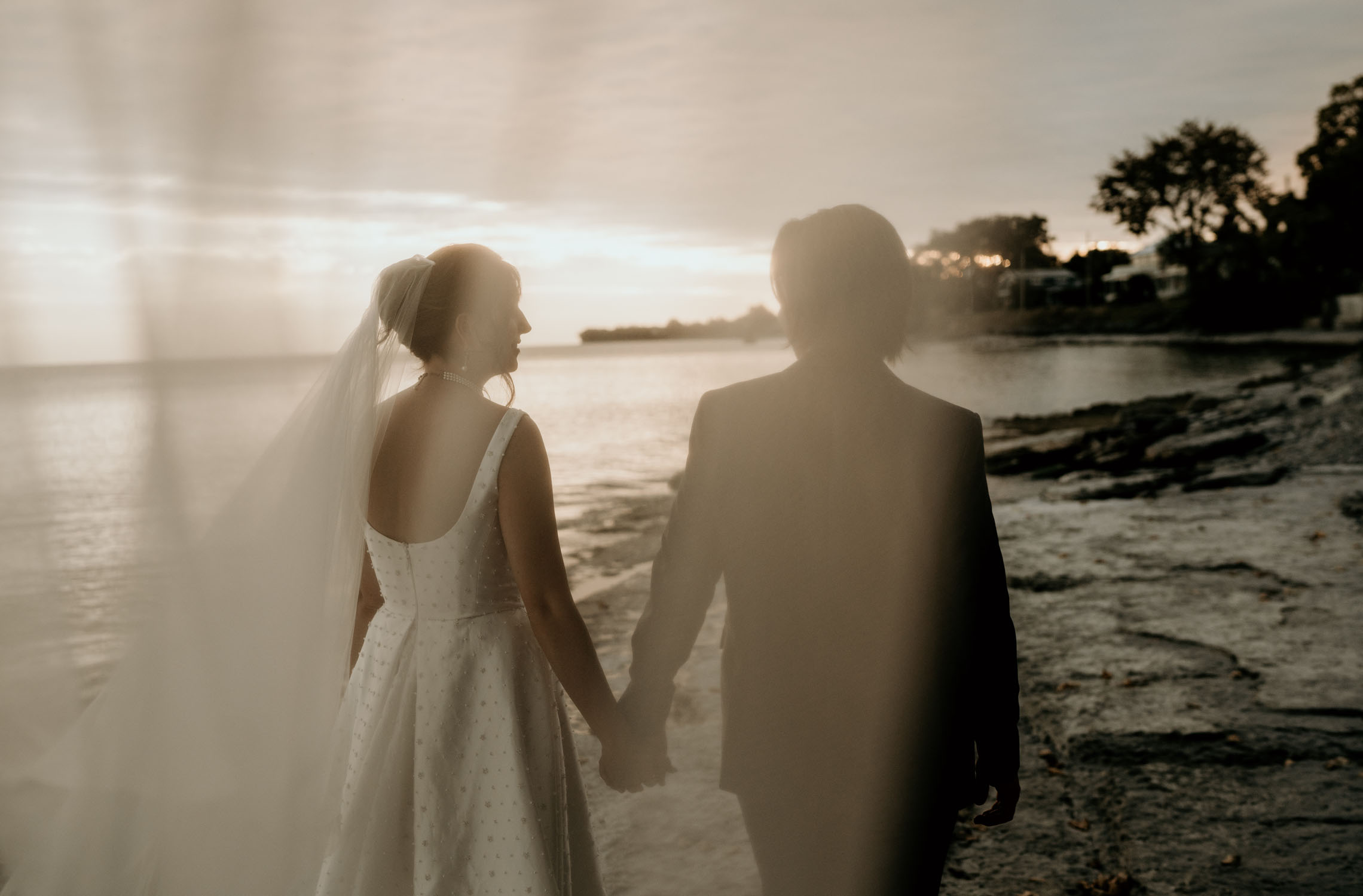 Bride and groom walking by Lake Ontario at Drake Devonshire wedding